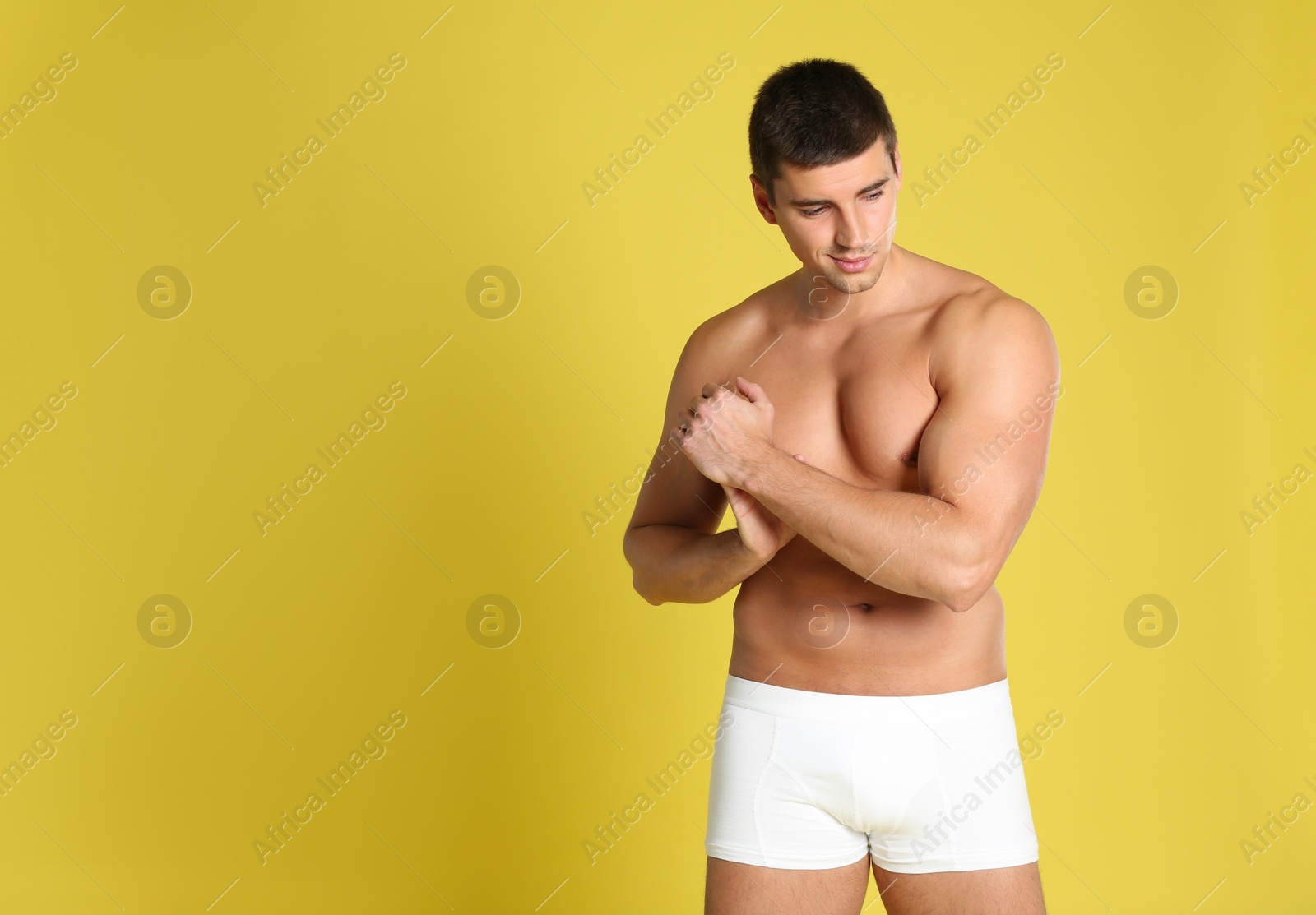 Photo of Man with sexy body on yellow background. Space for text