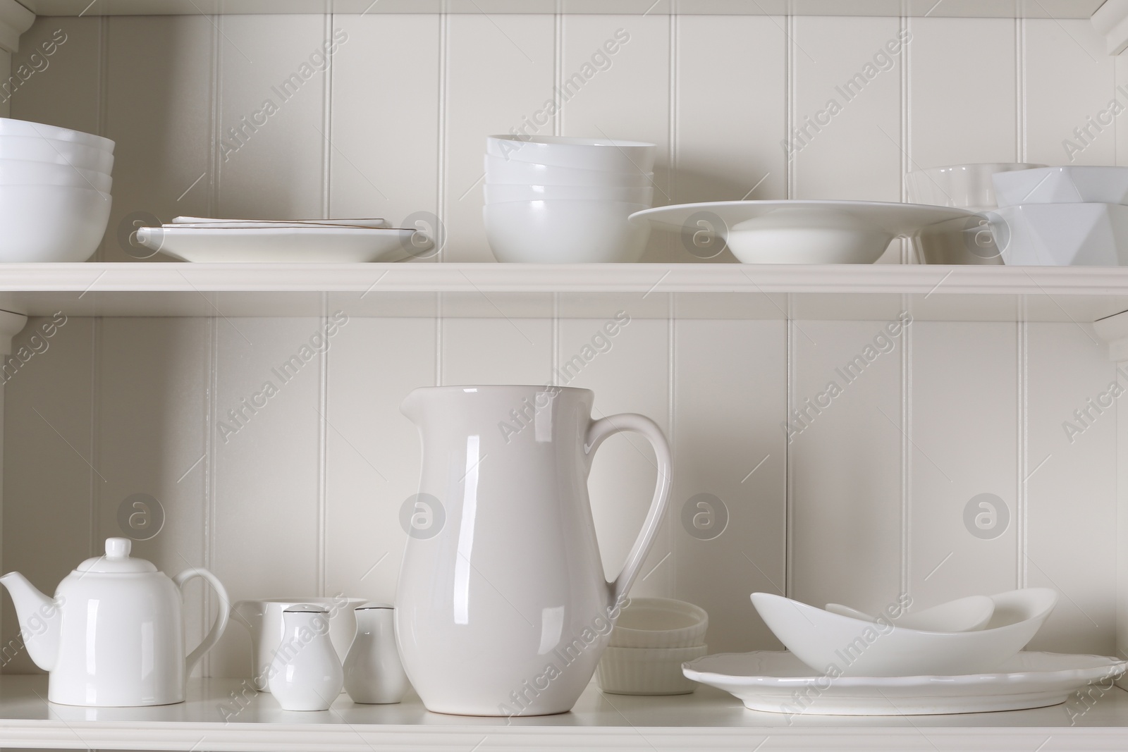 Photo of Stylish storage stand with different ceramic dishware at home