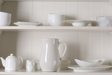 Stylish storage stand with different ceramic dishware at home