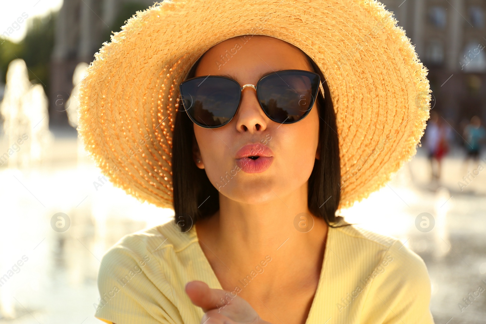 Photo of Beautiful young woman wearing stylish sunglasses outdoors, closeup