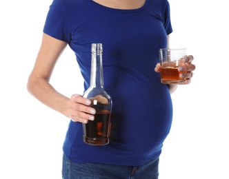 Photo of Future mother with bottle and glass of alcohol drink on white background, closeup. Bad habits during pregnancy