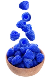 Fresh blue raspberries falling into bowl on white background