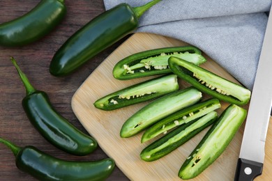 Photo of Fresh green jalapeno peppers on wooden table, flat lay