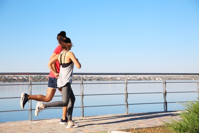 Sporty couple running outdoors on sunny morning