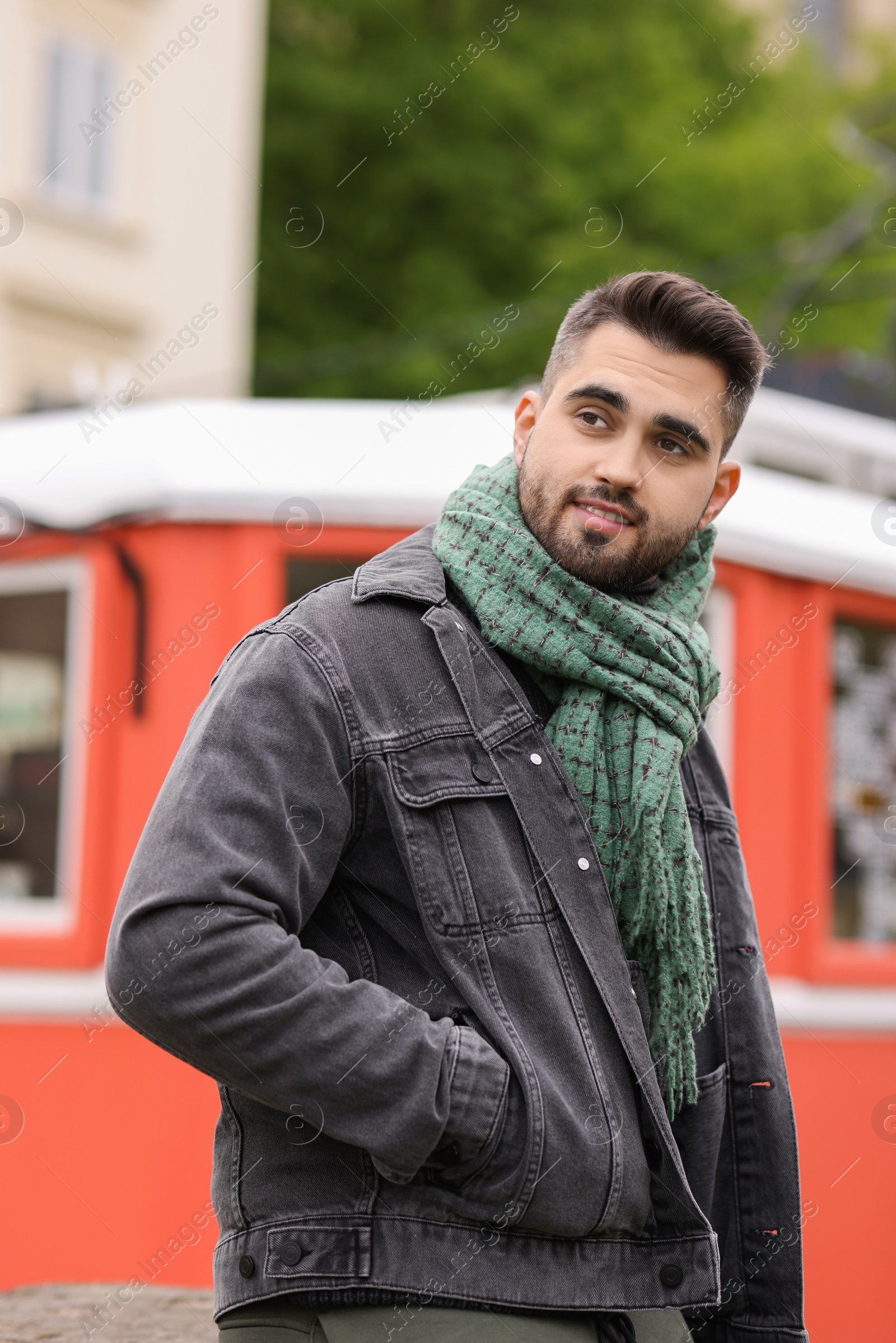 Photo of Smiling man in warm scarf on city street