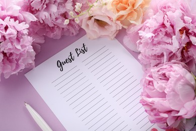 Photo of Guest list, pen and beautiful flowers on violet background, above view