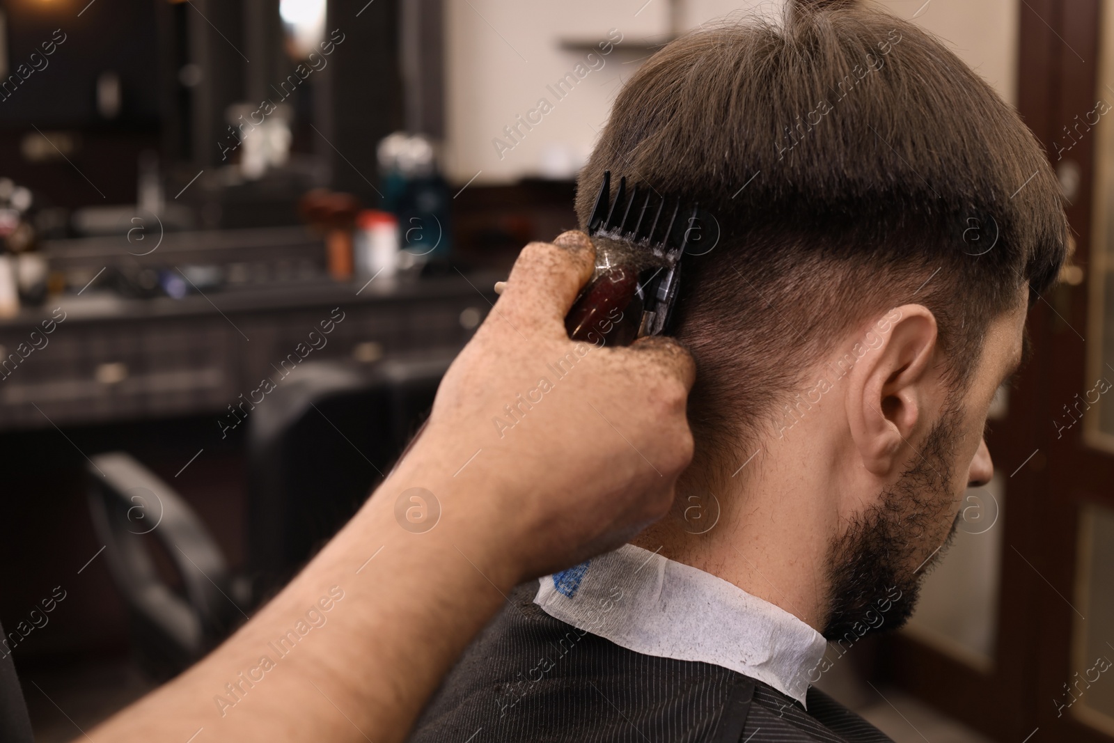 Photo of Professional hairdresser making stylish haircut in barbershop