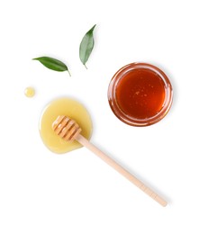 Photo of Tasty natural honey, glass jar, dipper and green leaves on white background, top view