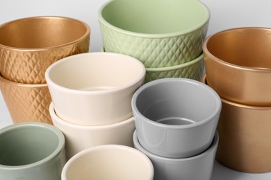 Photo of Many different empty ceramic flower pots on white background