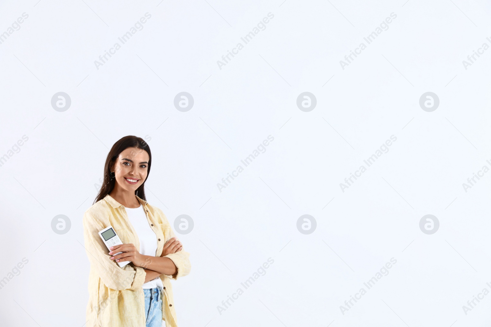 Photo of Young woman with air conditioner remote on white background