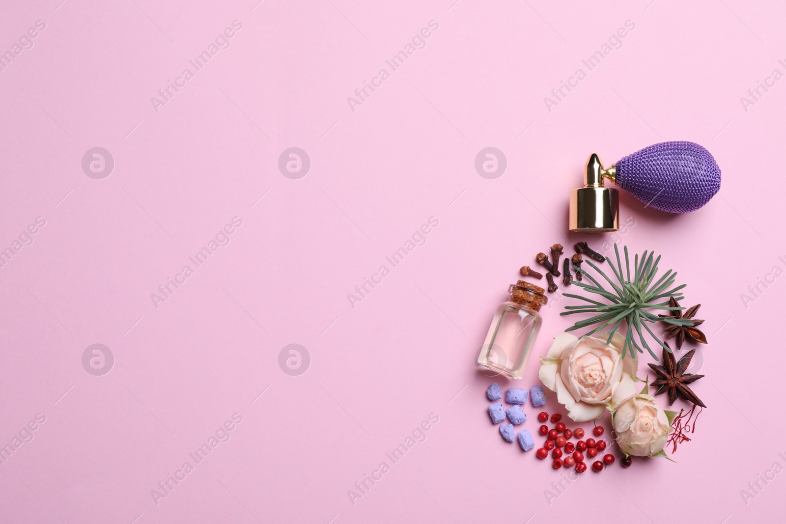 Photo of Bottle of luxury perfume and different ingredients on pink background, flat lay. Space for text