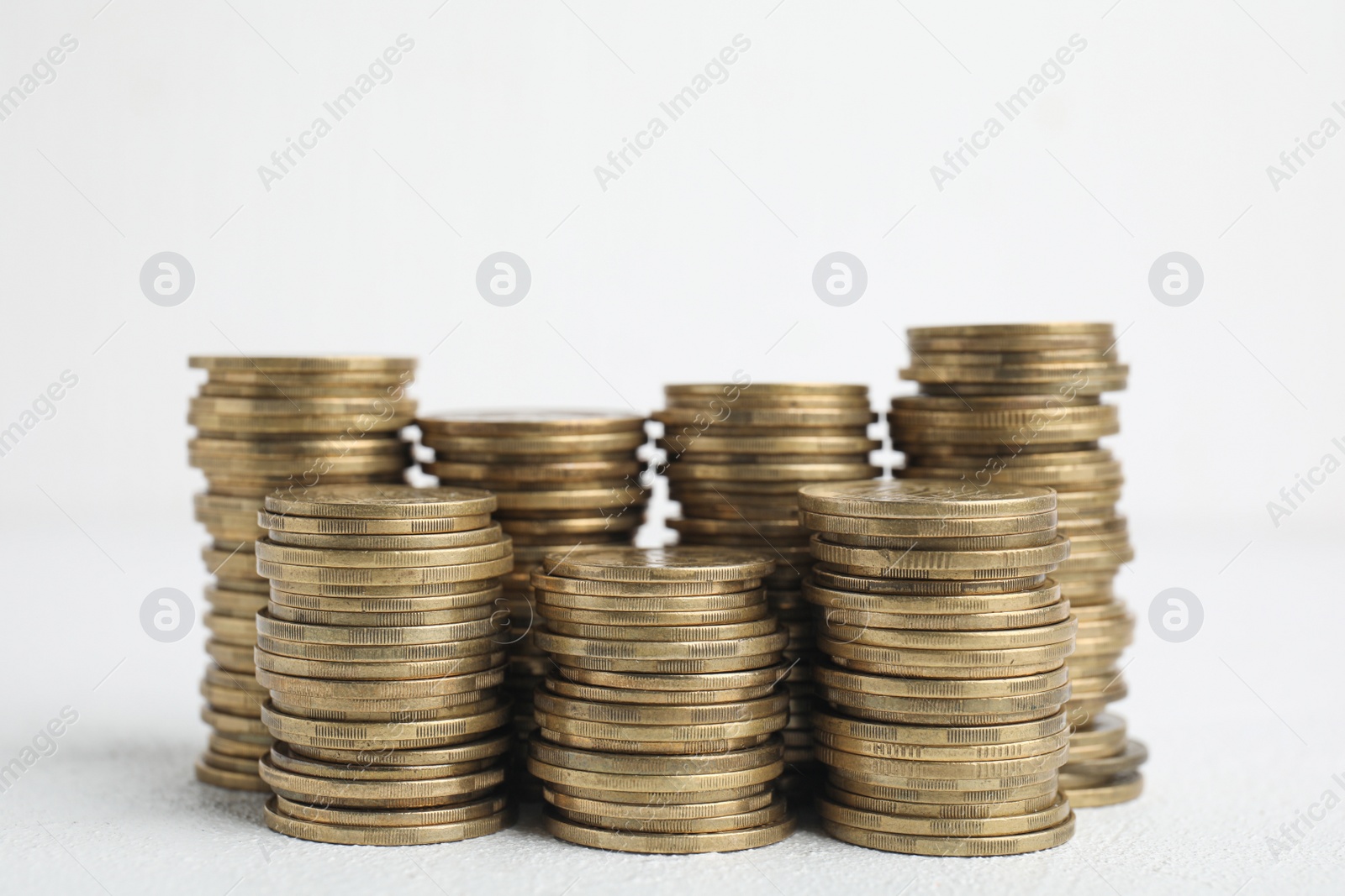 Photo of Many golden coins stacked on white table