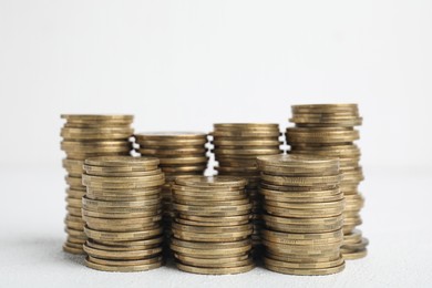 Photo of Many golden coins stacked on white table