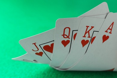 Photo of Hand of playing cards on green table, closeup. Poker game