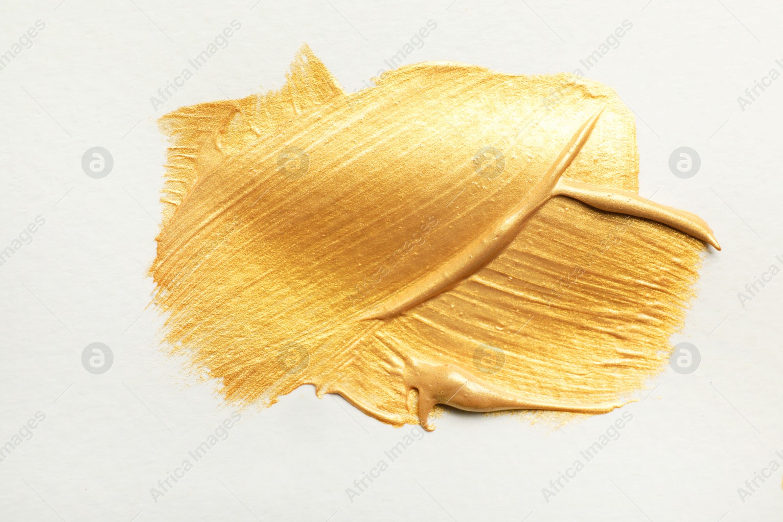 Photo of Golden paint brush strokes on white background