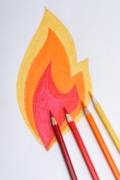 Photo of Drawing of fire and colorful pencils on white background, top view