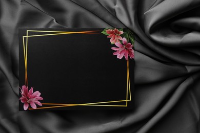 Photo of Blank invitation card on black fabric, top view. Space for text