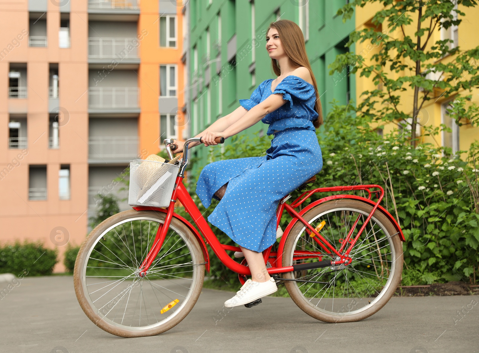 Photo of Young pretty woman riding bicycle in city