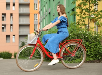 Photo of Young pretty woman riding bicycle in city