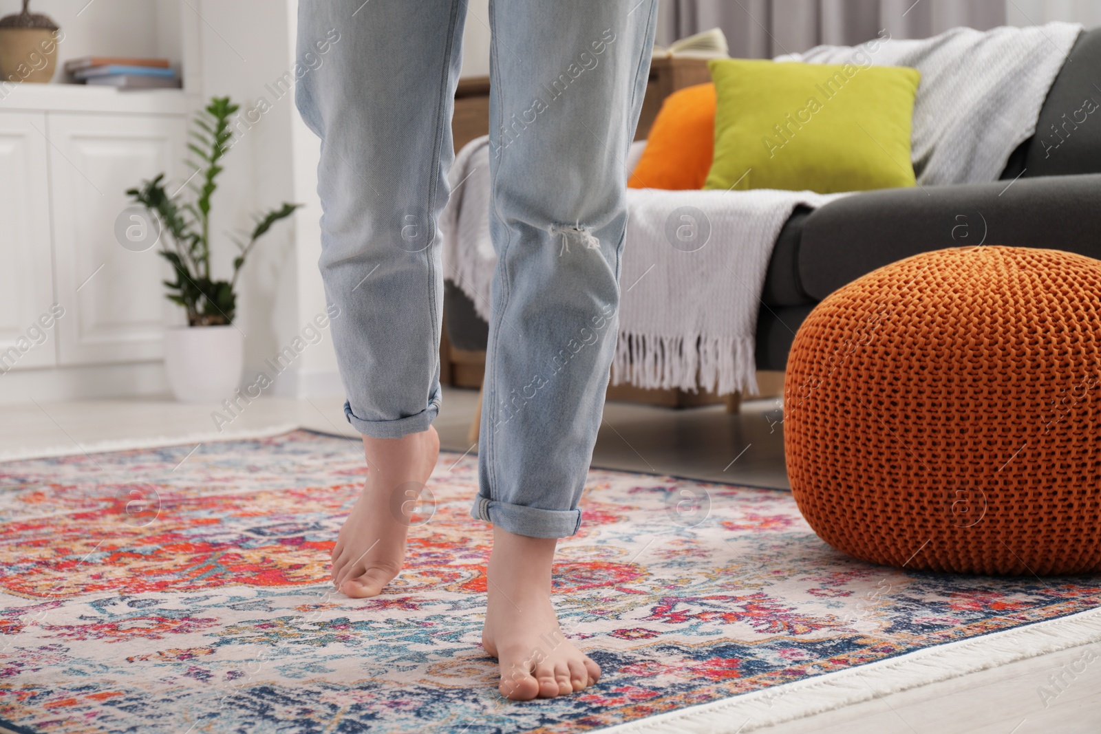 Photo of Woman standing on carpet with pattern in room, closeup