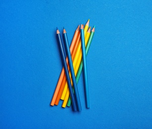 Photo of Color pencils on blue background, flat lay