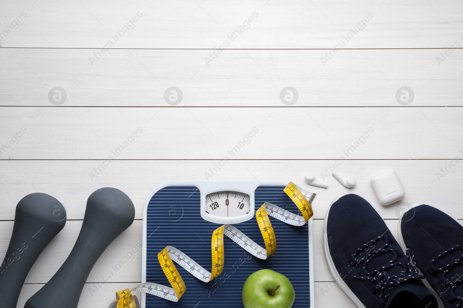 Photo of Flat lay composition with bathroom scale and measuring tape on white wooden floor, space for text. Weight loss concept