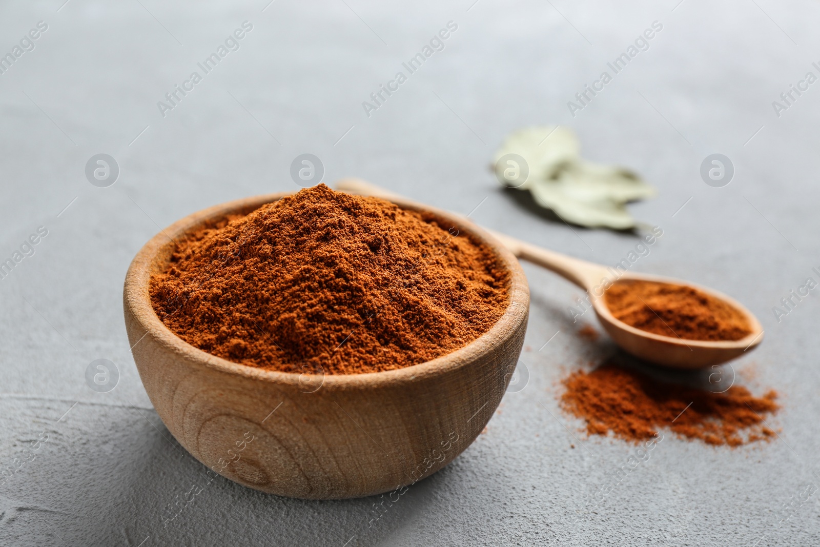 Photo of Ground red pepper in bowl on grey table