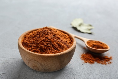 Photo of Ground red pepper in bowl on grey table