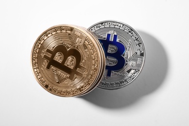 Golden and silver bitcoins on white background, top view. Digital currency