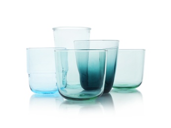 Photo of Set of colorful empty glasses on white background