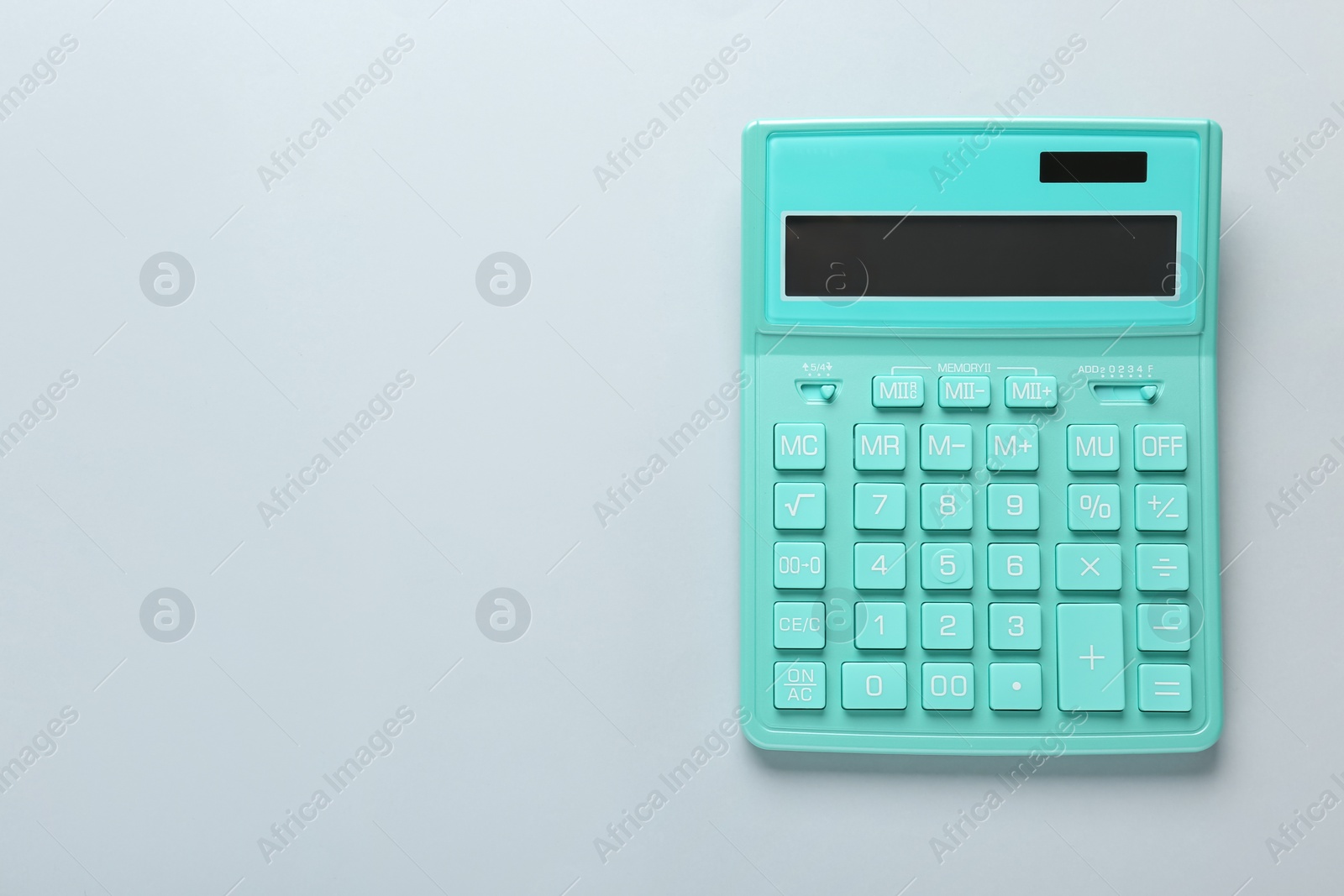 Photo of Turquoise calculator on light background, top view. Space for text