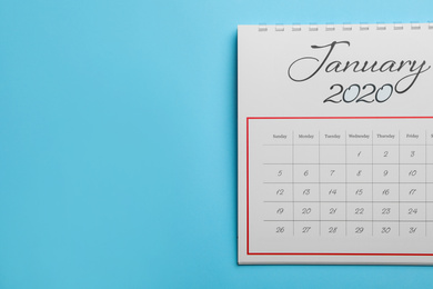 Photo of January 2020 calendar on light blue background, top view. Space for text