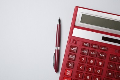 Calculator and pen on light grey background, flat lay with space for text