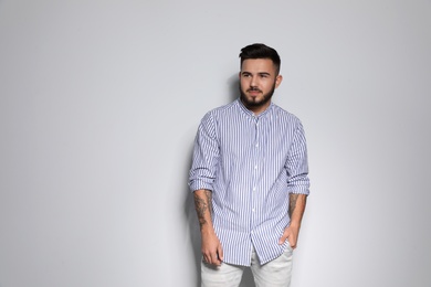 Portrait of handsome young man against light background