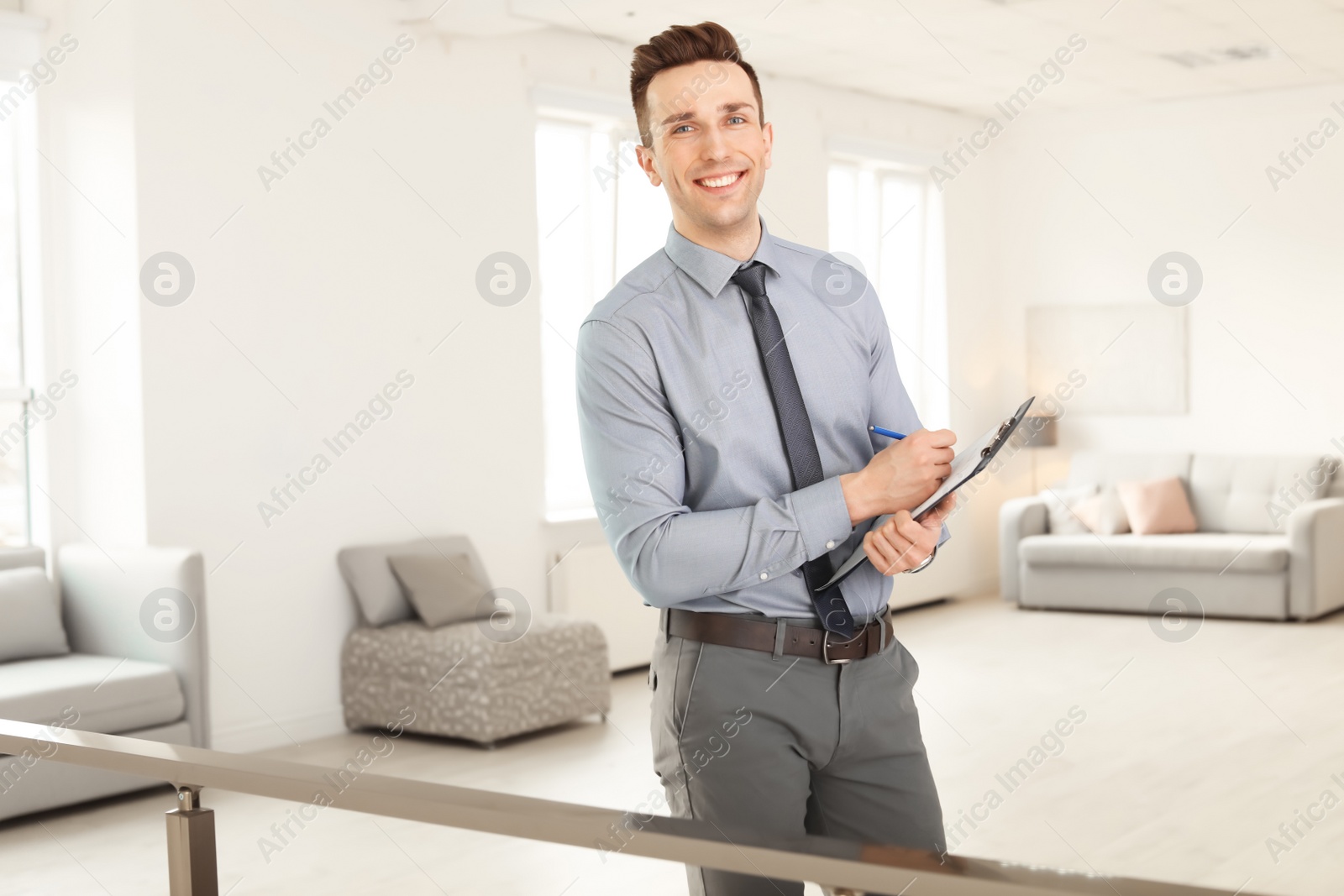 Photo of Male real estate agent with clipboard indoors