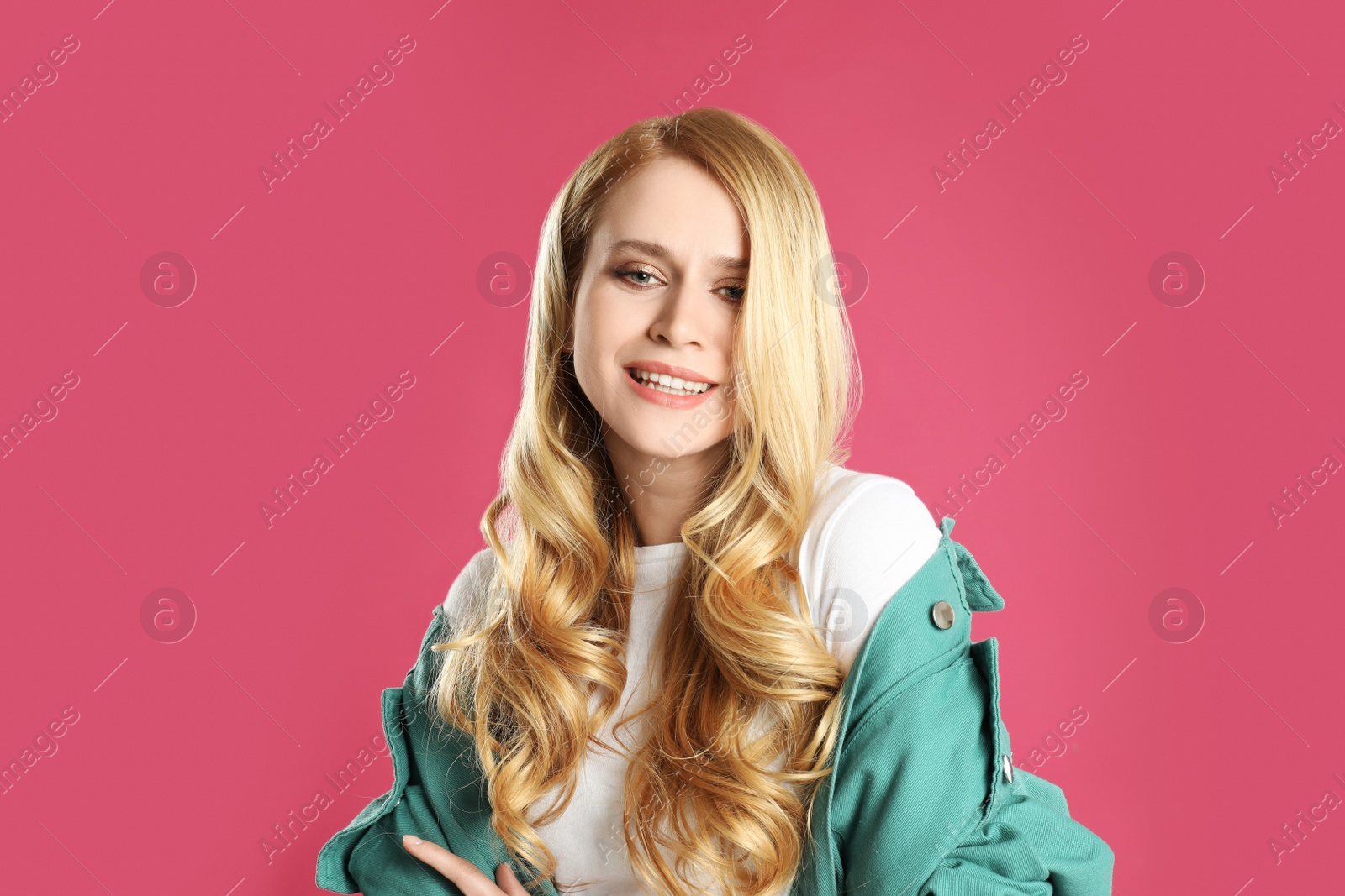 Photo of Portrait of beautiful young woman with dyed long hair on pink background