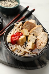 Photo of Delicious ramen served on white table, closeup. Noodle soup