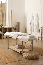 Stylish massage room interior with spa table in salon