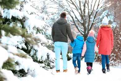 Photo of Happy family walking in winter park
