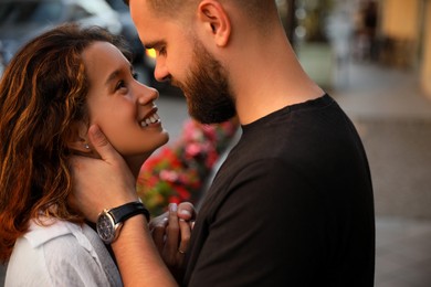 Photo of Happy young couple kissing on city street