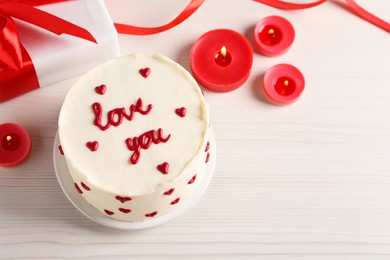 Bento cake with text Love You, candles, gift box and space for text on white wooden table, above view. St. Valentine's day surprise