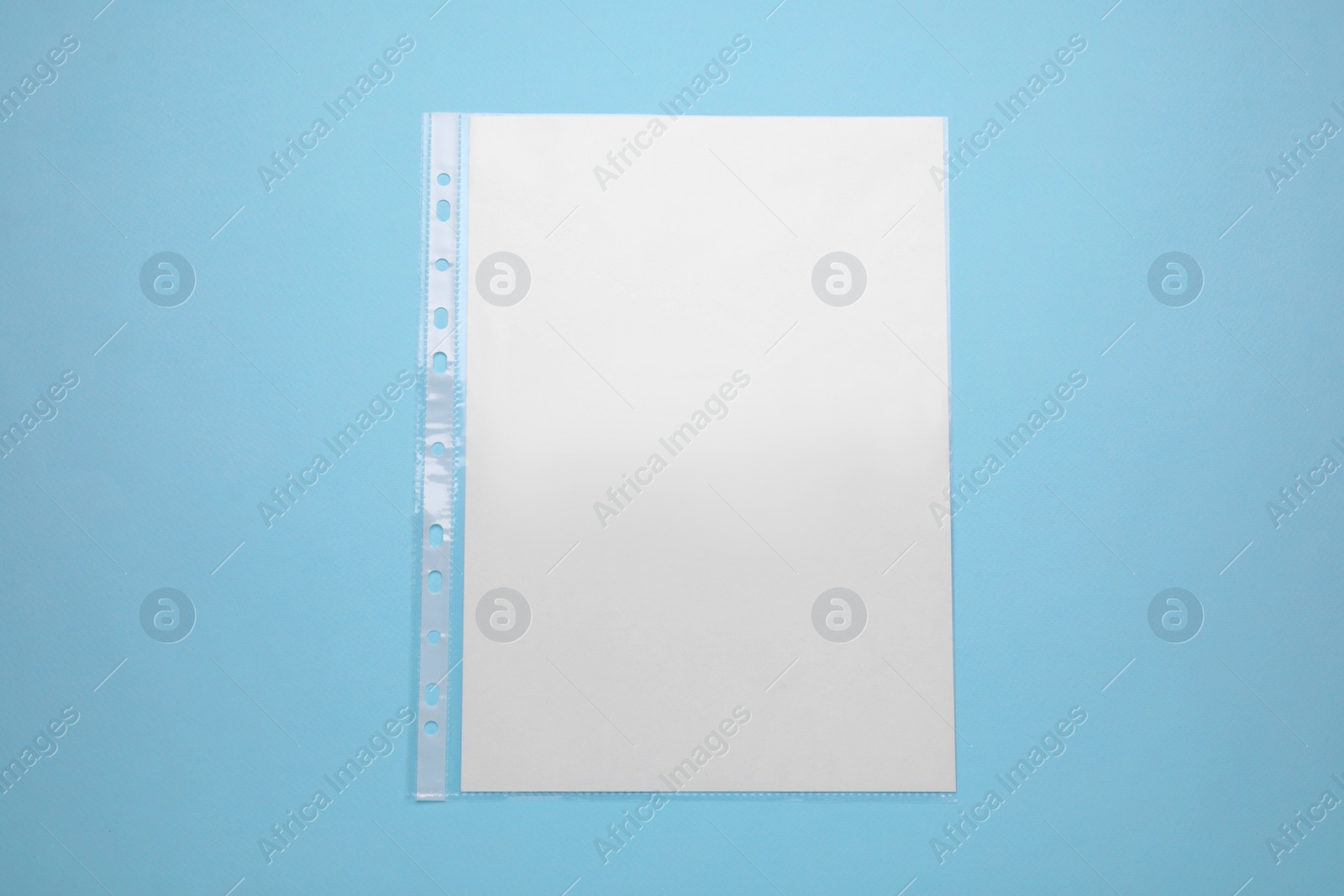 Photo of Punched pocket with paper sheet on turquoise background, top view