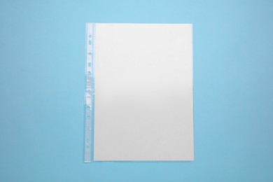 Photo of Punched pocket with paper sheet on turquoise background, top view