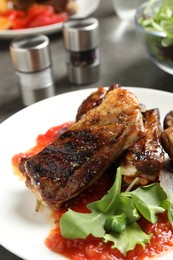 Delicious grilled ribs served on table, closeup