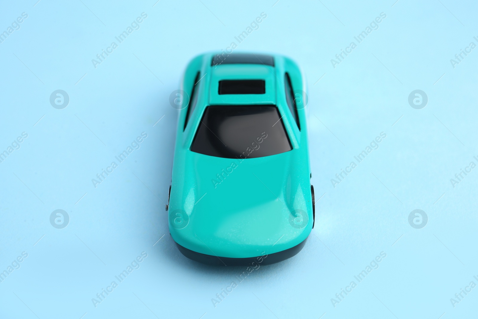 Photo of One bright car on light blue background. Children`s toy