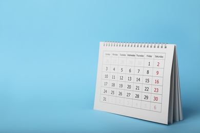 Photo of Paper calendar on light blue background, space for text. Planning concept