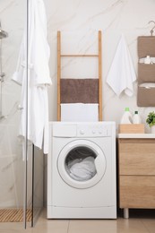 Photo of Stylish bathroom interior with modern washing machine