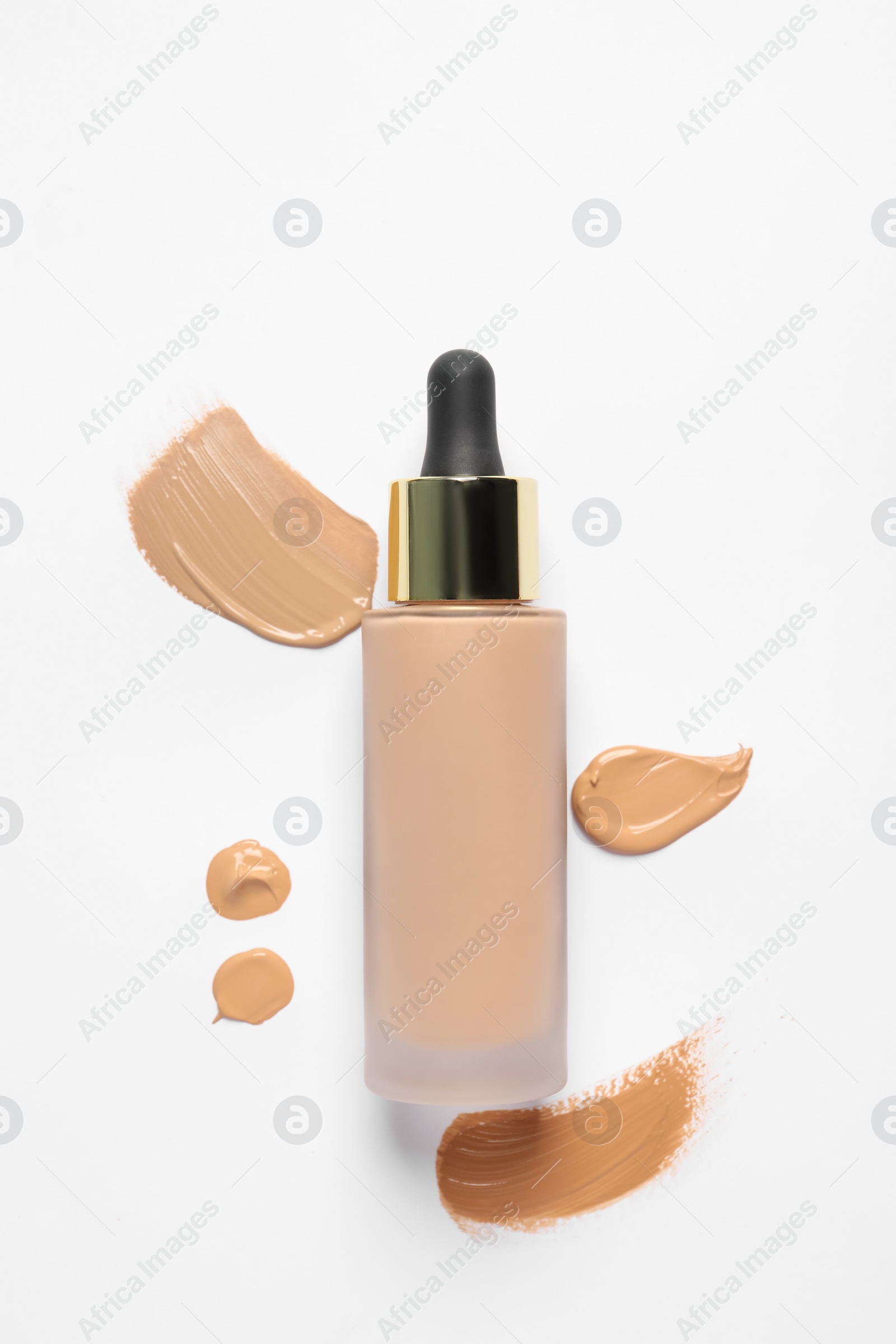 Photo of Liquid foundation and swatches on white background, top view