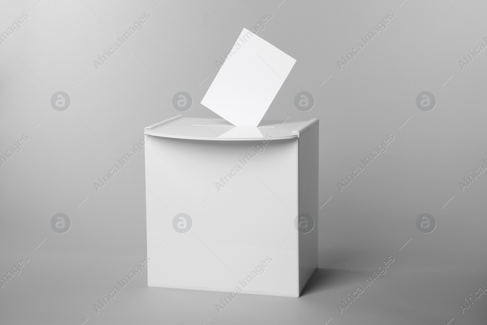 Photo of Ballot box with vote on light grey background. Election time