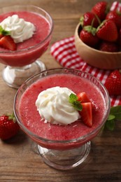 Photo of Delicious strawberry mousse with mint on wooden table